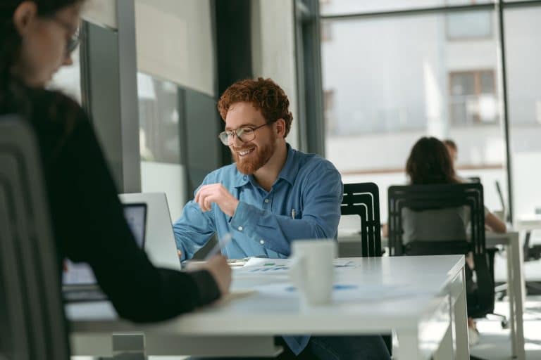 Handsome entrepreneur working on laptop sitting in modern coworking during working day